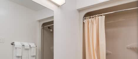 Ein modernes Badezimmer mit einem Doppelwaschbecken, Toilette und einer Dusche mit beiger Duschvorhang.