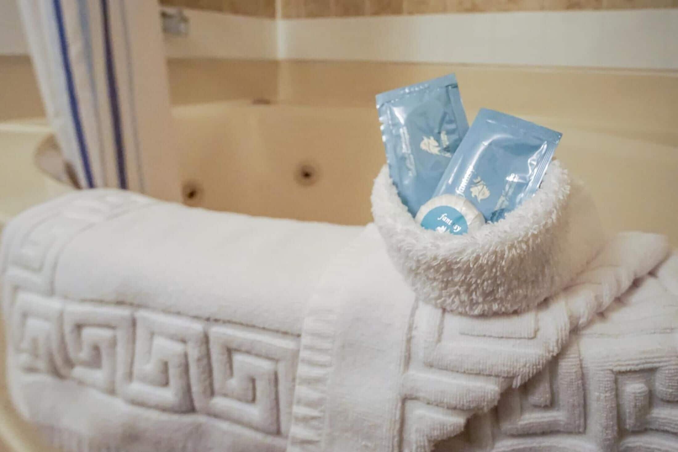 A white towel with a geometric pattern on a bed.