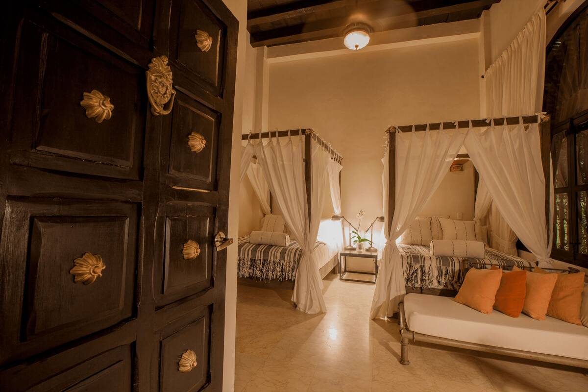 Una habitación con cama, sofá y mesita de noche.