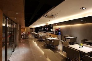 A restaurant with multiple tables and chairs, a counter with a display, and a tiled floor. - Jinjiang Inn (Beijing Wangfujing) (Beijing)