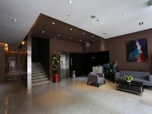 A modern lobby with a staircase, seating area, and artwork on the wall. - Jinjiang Inn (Beijing Wangfujing) (Beijing)