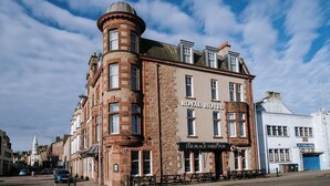 A historic building with a prominent corner turret and a sign reading "ROYAL HOTEL".