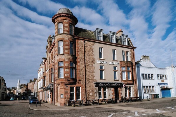 A historic building with a prominent corner turret and a sign reading "ROYAL HOTEL".