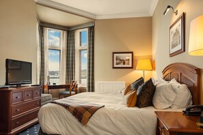 A hotel room with a bed, a desk, a television, and a view of the water. - The Royal Hotel Campbeltown  (Campbeltown)