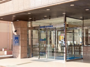 A modern building entrance with glass doors and a sign indicating an emergency room. - Toyoko Inn Sasebo Ekimae (Sasebo)