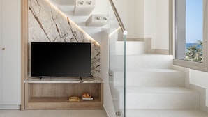 A modern staircase with a marble wall and a flat-screen TV on the landing. - Iperion Beach (Rethymno)