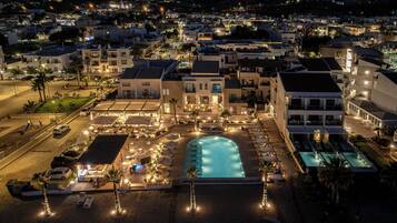 Een resort met een zwembad, terras en uitzicht op de omgeving.