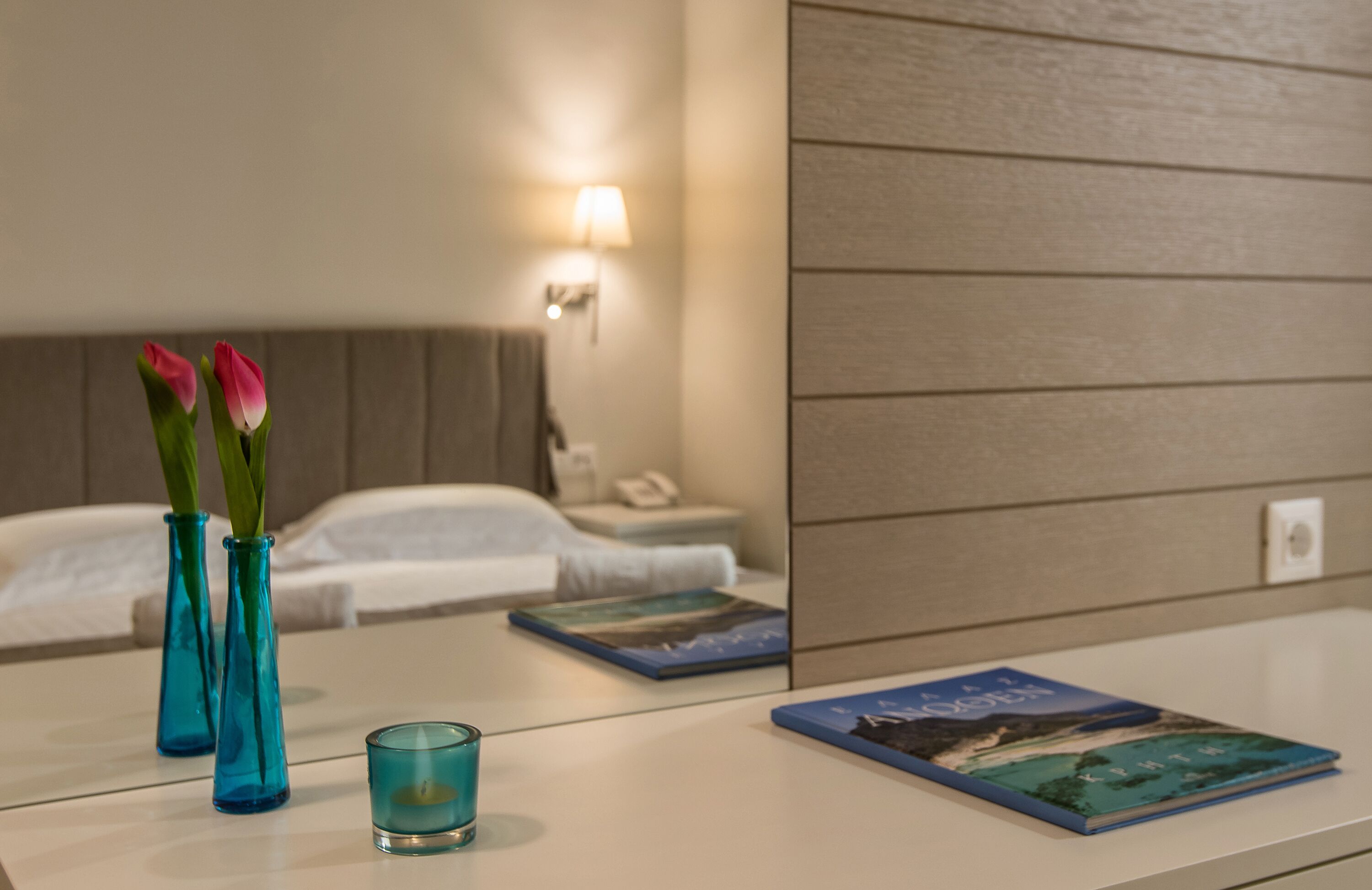 Een hotelkamer met een bed, nachtkastje en een nachtkastje met een lamp.