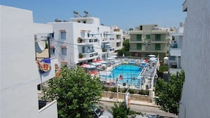 A residential area with a swimming pool surrounded by balconies and white buildings. - Sevi Sun Studios and Apartments (Kos)