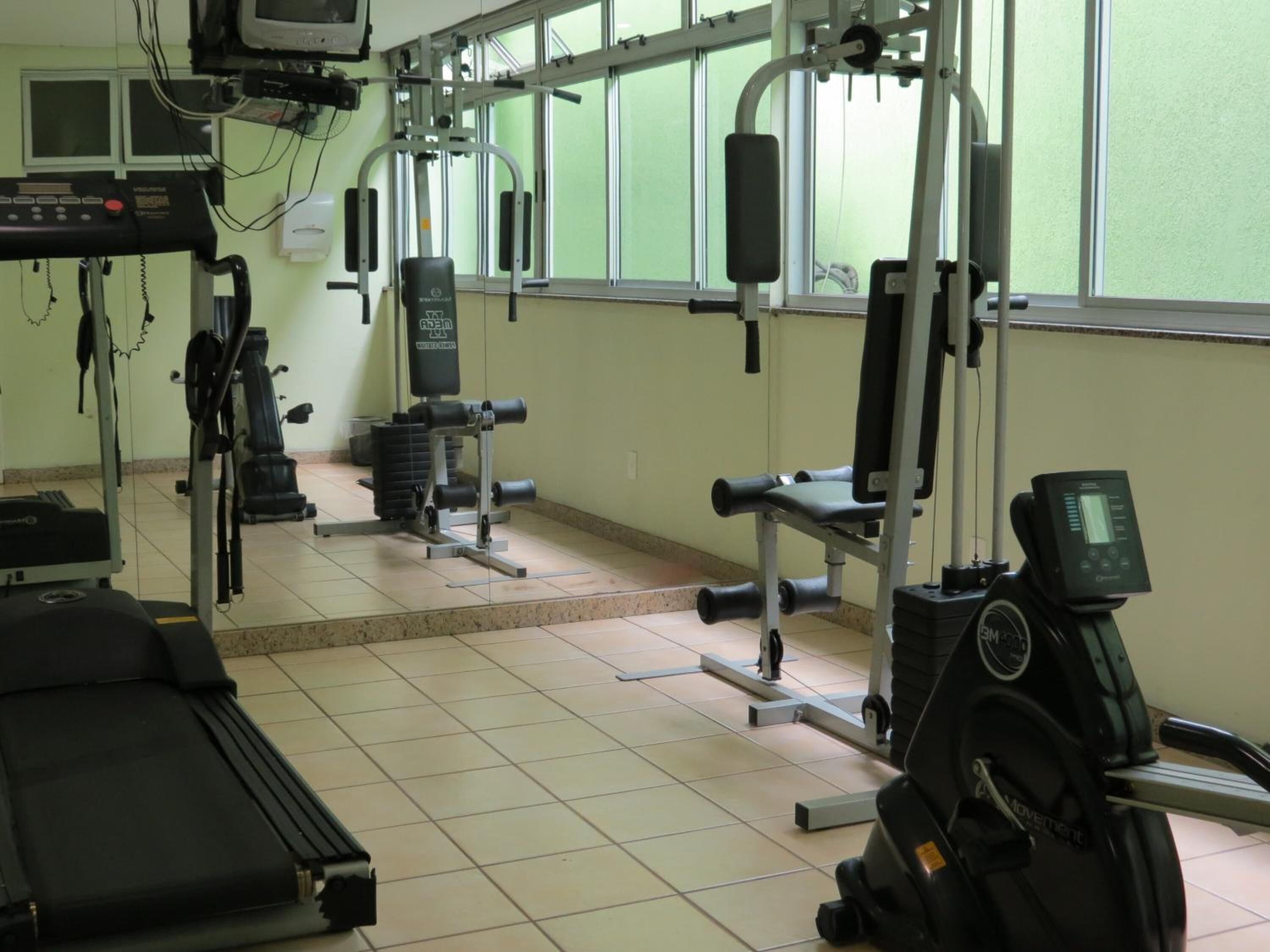 A gym with various exercise equipment, including a treadmill, weight machines, and a stationary bike.