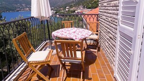 A balcony with a table, chairs, and a white umbrella. - Villa Marijeta (Dubrovnik)