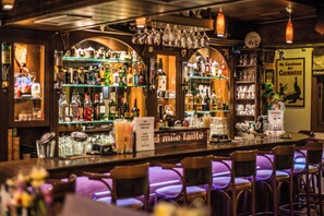 A bar area with shelves of bottles, glasses, and a menu sign. - Stefania Studios (Hersonissos)