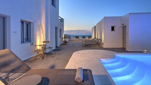 A rooftop terrace with sun loungers, a pool, and a view of the sea. - Papadakis (Paros)