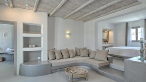 A modern living room with a curved sofa, a small coffee table, and built-in shelving. - Papadakis (Paros)