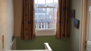 A narrow stairway with a white handrail, a window with floral curtains, and a green wall. - The Coach House Canterbury (Canterbury)