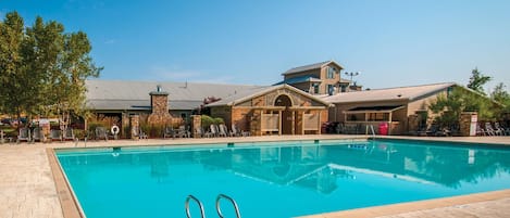Una piscina al aire libre de temporada, sombrillas