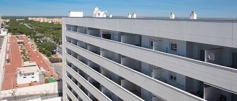 A multi-story building with a flat roof, multiple balconies, and a clear view of the surrounding area.