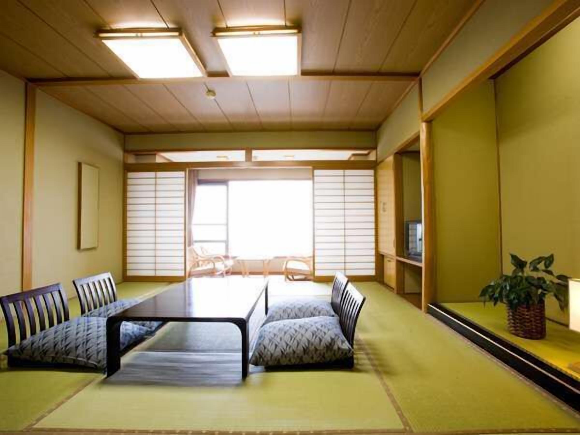 A traditional Japanese-style room with tatami flooring, a low table, and a sofa.