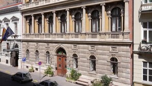 Un edificio histórico con fachada simétrica, numerosas ventanas y una entrada central.