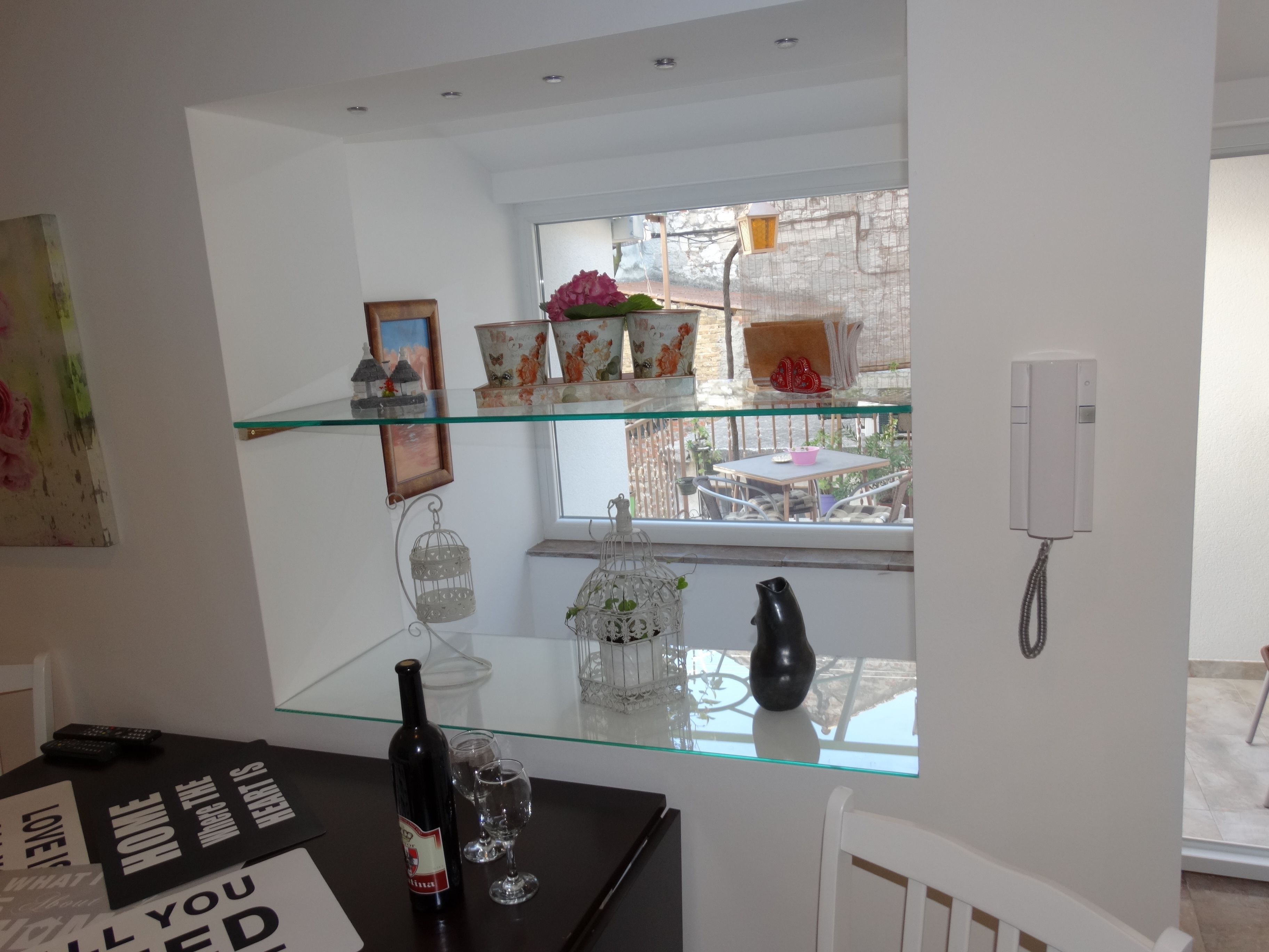 Una cucina moderna con isola in vetro, un tavolo da pranzo con sedie e vista all'esterno.