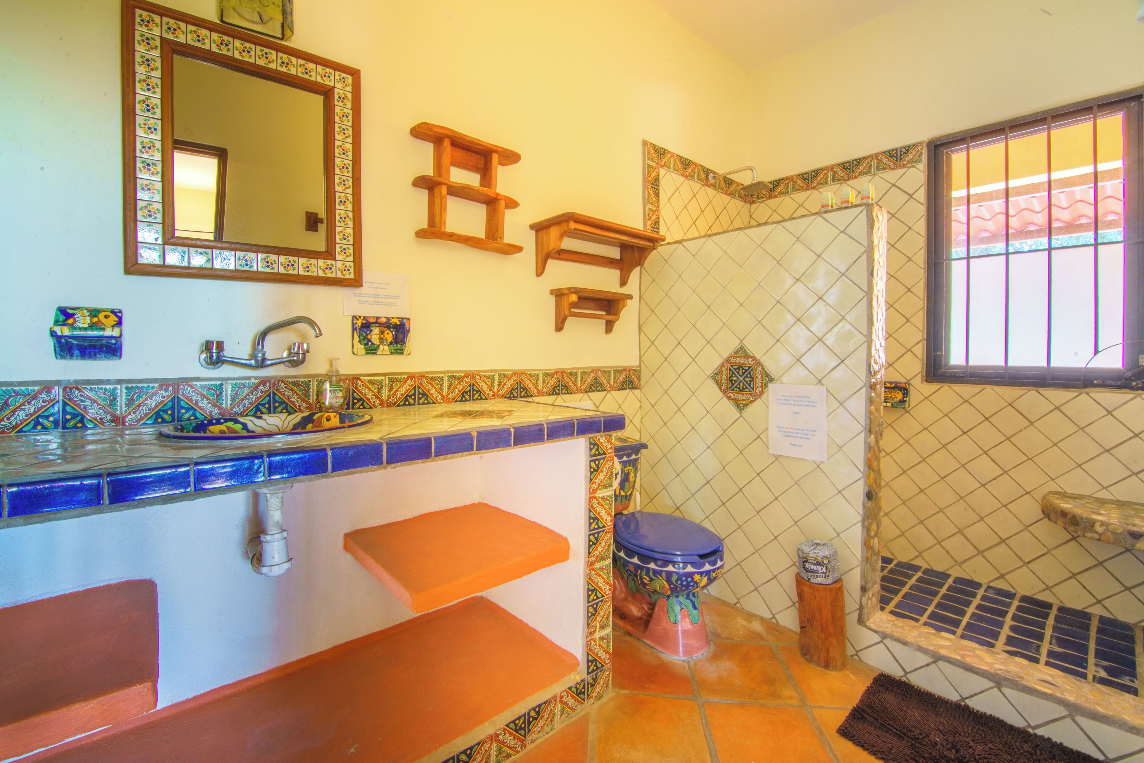 Un baño con piso de baldosas, un lavamanos con grifo, un inodoro y una zona de ducha.