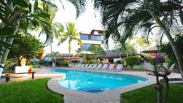 Alberca al aire libre, sombrillas en la alberca y camastros