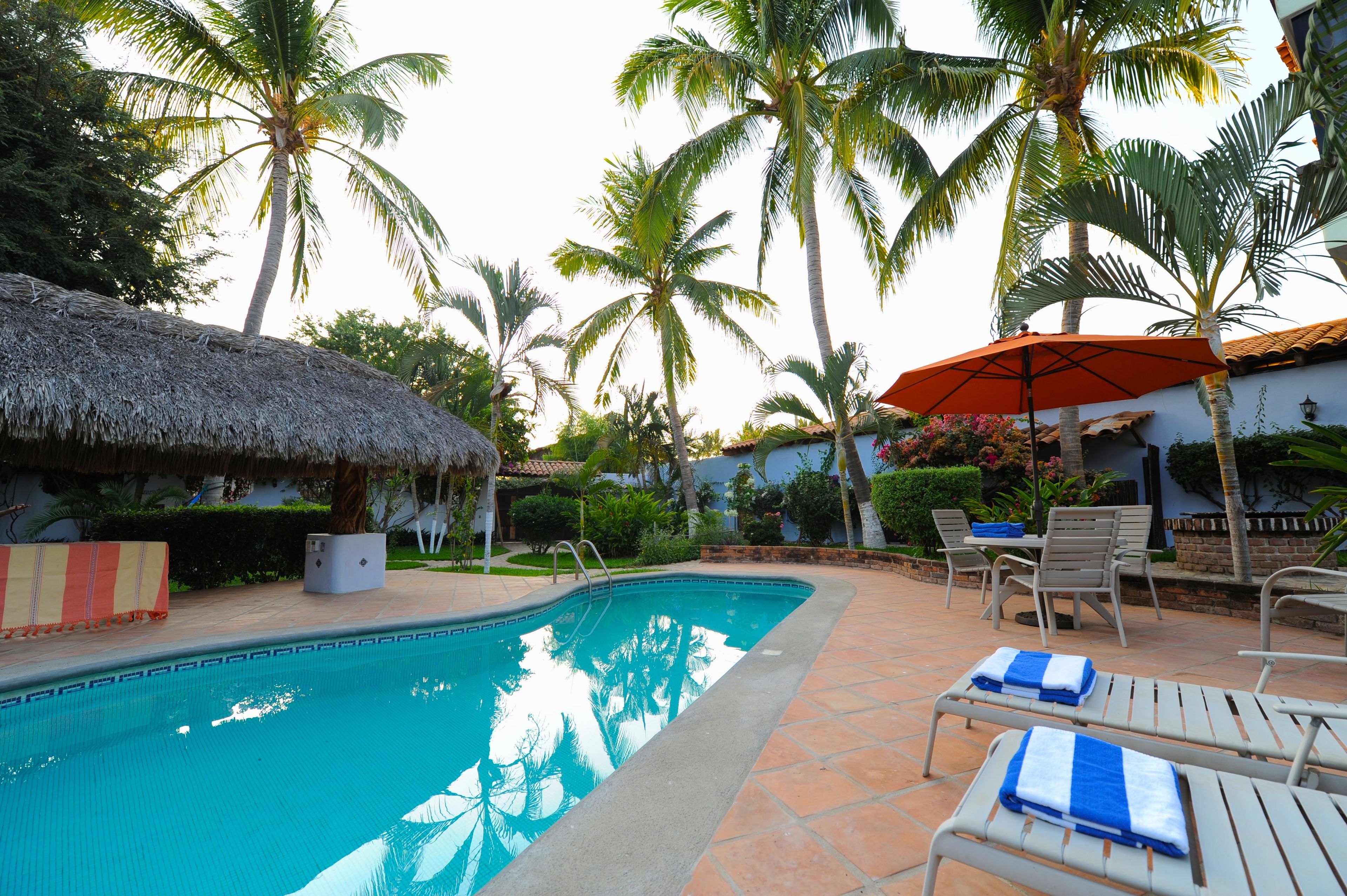 Alberca al aire libre, sombrillas en la alberca y camastros 