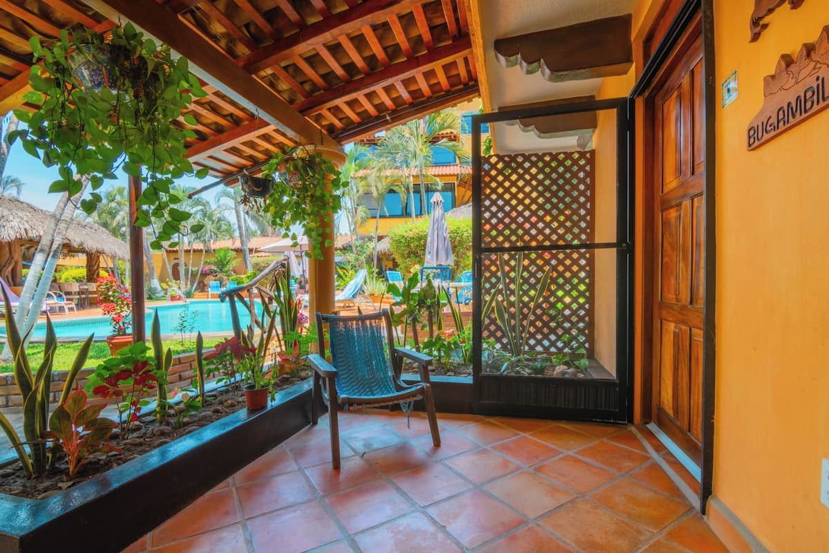Un patio con piscina, sillas y un letrero de madera.