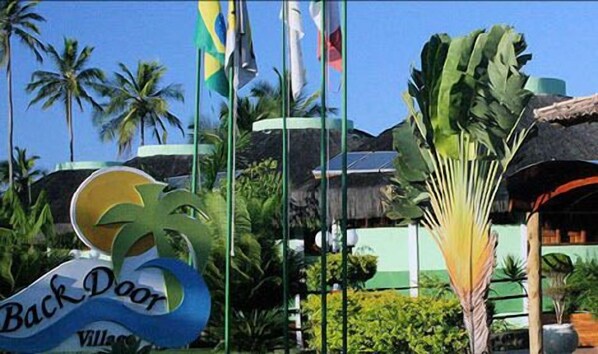 A sign with palm trees and flags, indicating a tropical location.