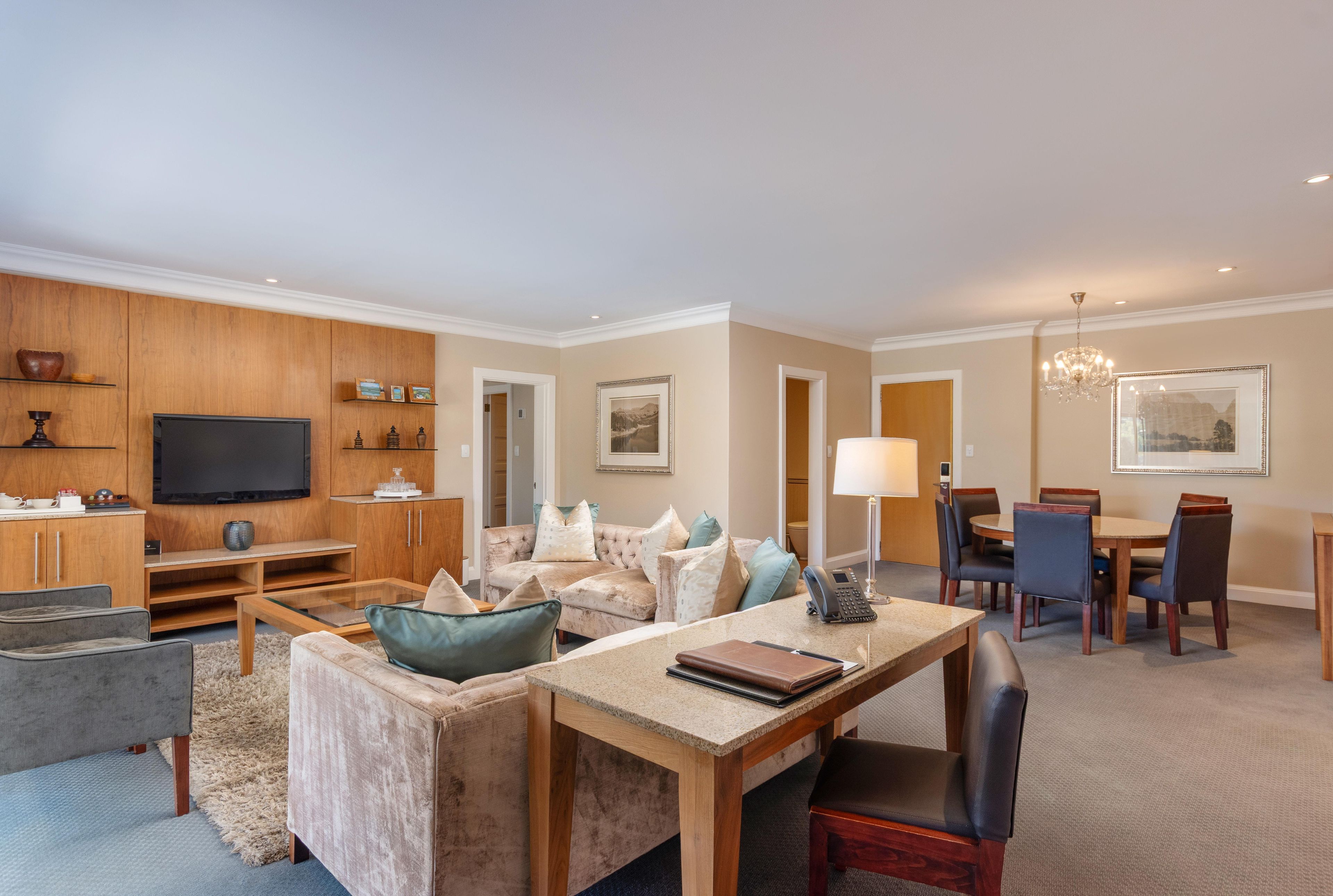 A spacious living room with a television, seating area, and a dining space.