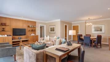 A spacious living room with a television, seating area, and a dining space.