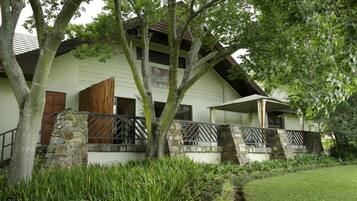 A two-story building with a stone staircase, a wooden door, and a balcony.