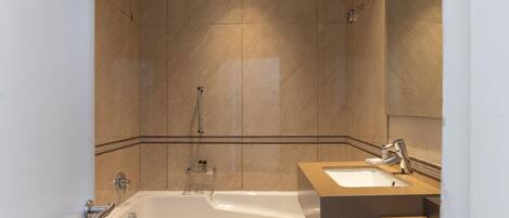 A modern bathroom with a bathtub, a sink, and a mirror.