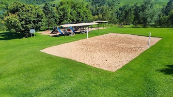 A park with a sandbox, playground equipment, and picnic tables.