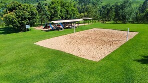 A park with a sandbox, playground equipment, and picnic tables. - Drakensberg Sun (Cathkin Park)