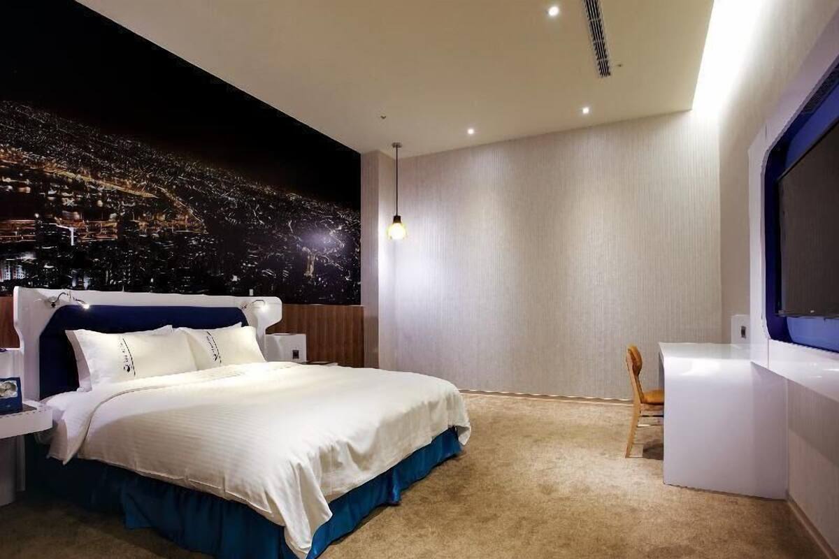 Une chambre à coucher moderne avec un lit, une table de chevet et une chaise.