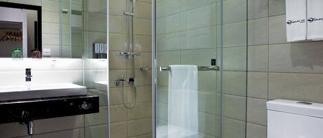 A modern bathroom with a glass-enclosed shower, a white sink, and a toilet.