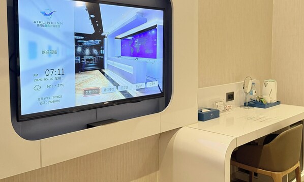 A hotel reception area with a digital display, a white reception desk, and a seating area. - Airline lnn Green Park Way (Taichung)