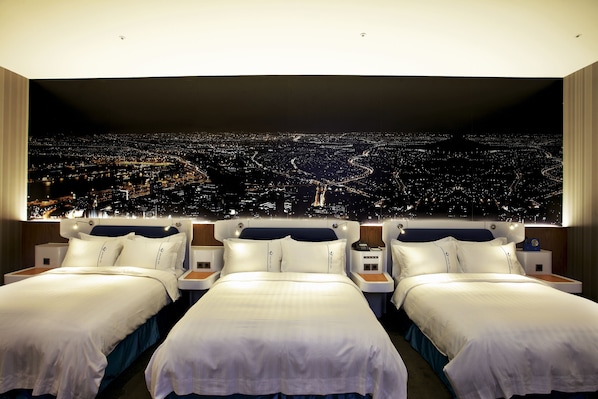 Habitación de hotel con dos camas, amplia vista panorámica de la ciudad y diseño moderno.
