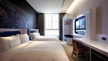 A hotel room with two beds, a desk, a TV, and a large window.