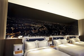 Un moderno cuarto de hotel con amplia vista a la ciudad, dos camas y una mesita de noche.