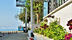 A cafe with outdoor seating, a view of the sea, and a sign indicating it is a cafe and restaurant. - Gumuldur Mavi Deniz Otel (Menderes)