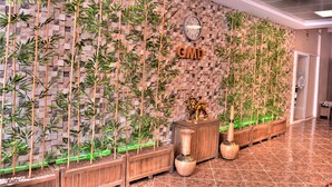 A lobby with a bamboo wall, a clock, and a wooden cabinet with a lion statue. - Gumuldur Mavi Deniz Otel (Menderes)