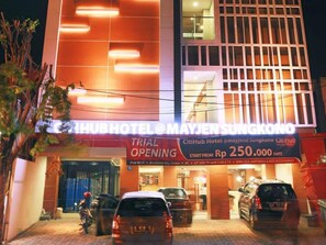 Een hotel met een bord waarop staat 'proefopening' en een startprijs van Rp 250.000.