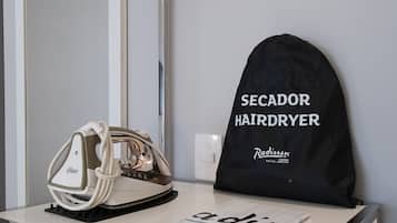 Hiustenkuivaaja ja laukku, jossa on merkintä ”Secador Hairdryer”, ovat tiskillä.