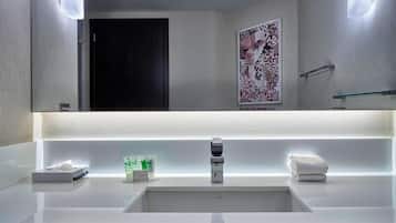 A modern bathroom with a large mirror, two sinks, and a towel rack.