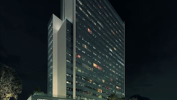 A Courtyard Residence Inn hotel with a modern design, featuring a prominent vertical structure and a well-lit entrance.