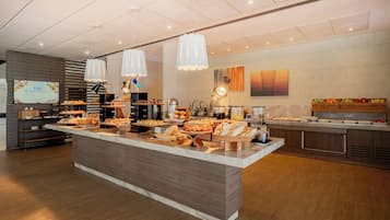 A buffet area with various food items and a coffee station.
