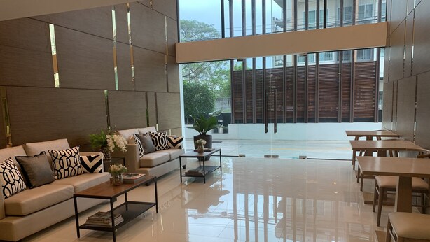 A modern interior with a sofa set, coffee table, and dining area. - 185 Residence (Khon Kaen)