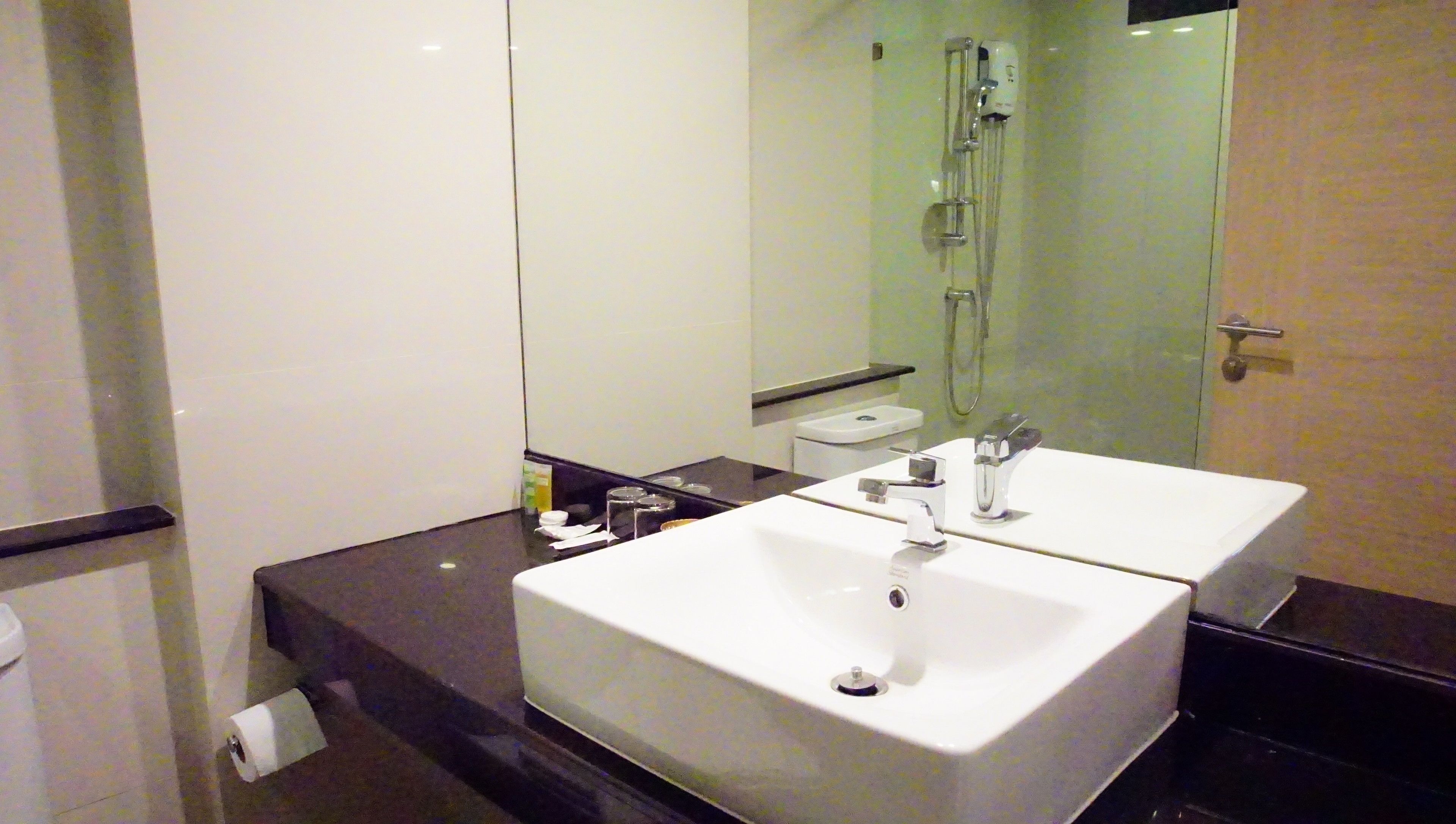 A bathroom with two sinks, a toilet, and a shower.